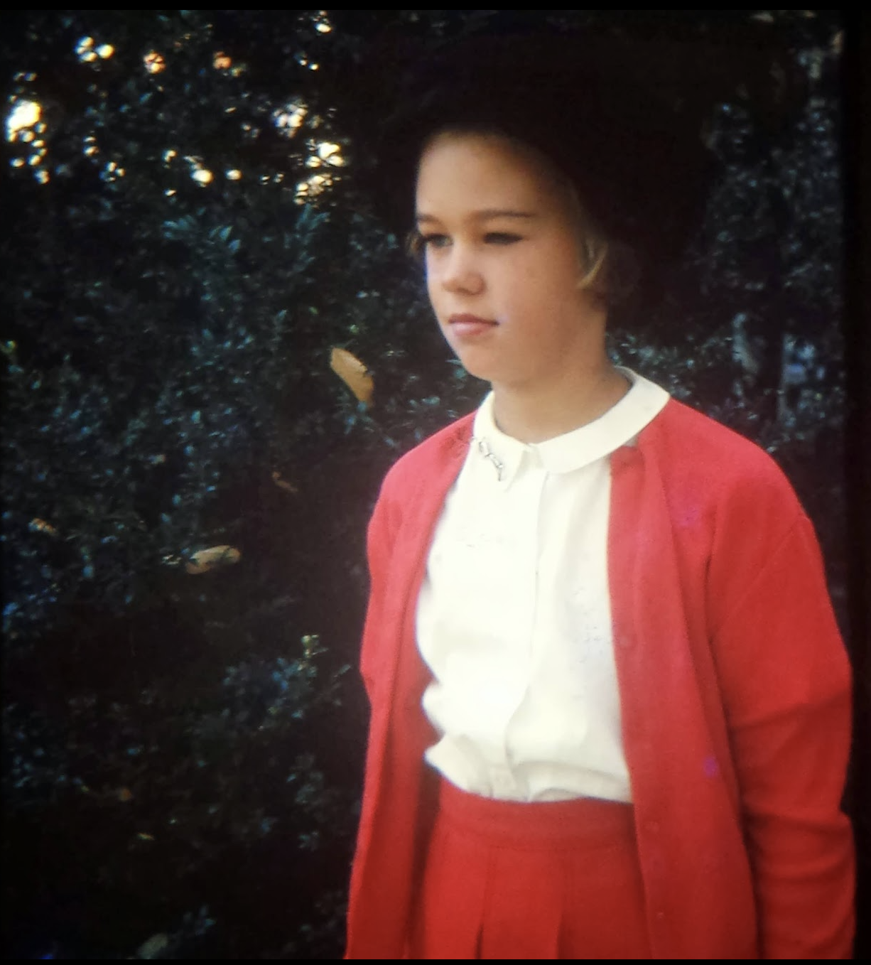 Liza as a girl in a red cardigan
