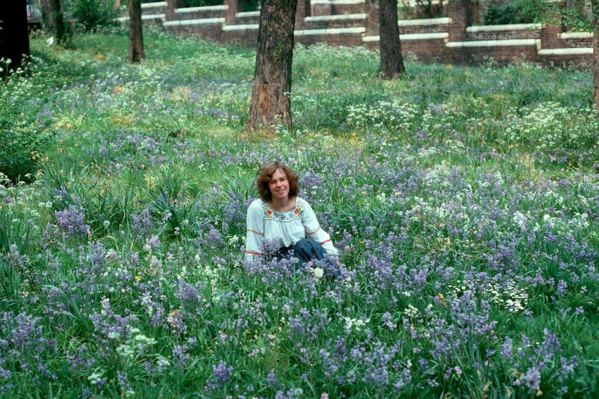 Young Elizabeth sitting in a field of wildflowers, 1976