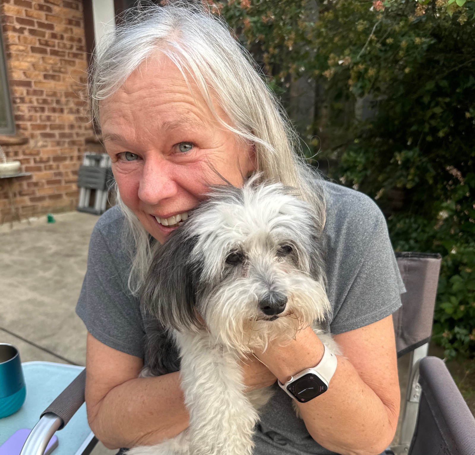 Elizabeth Haywood smiling and hugging her dog Sparky